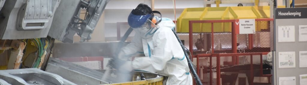 Operator in safety equipment using a dry ice cleaning machine.